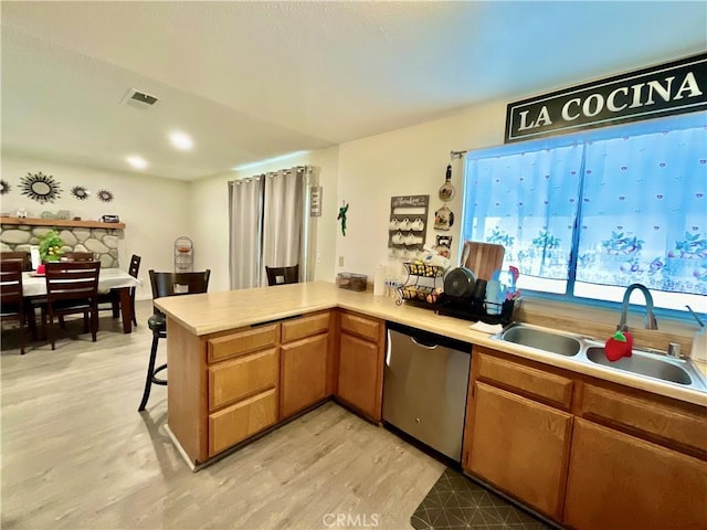 1078 W King St, Banning, CA 92220 - kitchen with light wood-style flooring, a sink, light countertops, dishwasher, and a peninsula