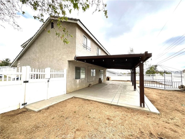 1078 W King St, Banning, CA 92220 - rear view of property with stucco siding, fence, a gate, and a patio