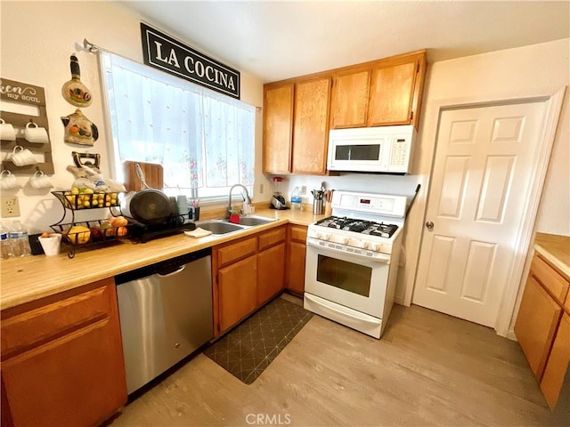 1078 W King St, Banning, CA 92220 - kitchen featuring light wood-style flooring, white appliances, light countertops, and a sink