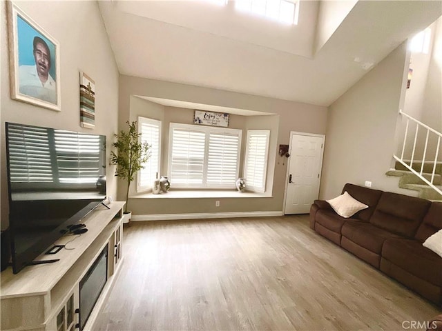 1078 W King St, Banning, CA 92220 - living room with stairway, wood finished floors, vaulted ceiling, and baseboards