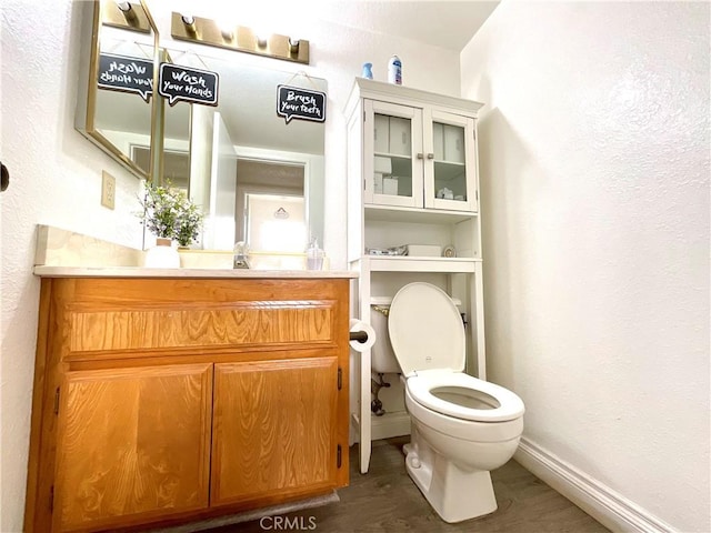 1078 W King St, Banning, CA 92220 - bathroom with toilet, a textured wall, vanity, and baseboards