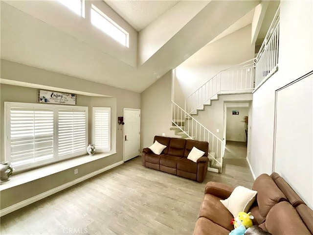 1078 W King St, Banning, CA 92220 - living room featuring baseboards, wood finished floors, stairs, and a towering ceiling