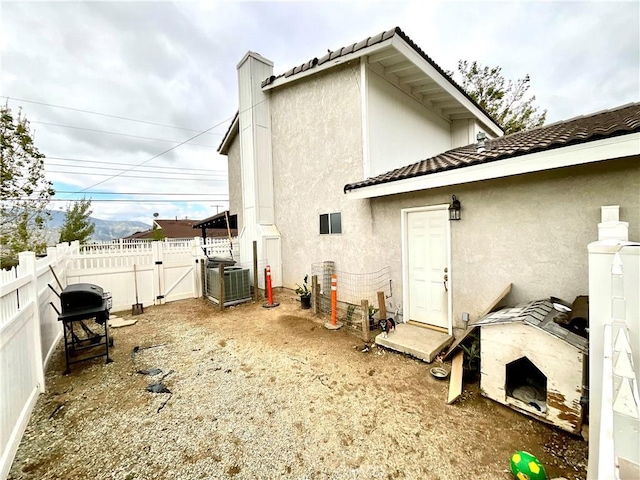 1078 W King St, Banning, CA 92220 - rear view of property with fence, a gate, a tiled roof, stucco siding, and central AC unit