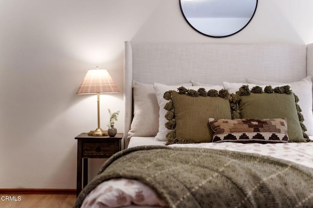bedroom with baseboards and wood finished floors