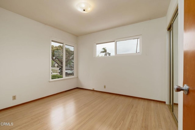 spare room with light wood finished floors and baseboards