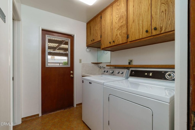 washroom featuring separate washer and dryer and cabinet space