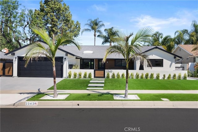 view of front of house featuring an attached garage, driveway, and a front lawn