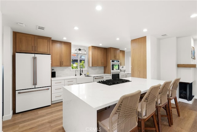 2343 E Athens Ave, Orange, CA 92867 - kitchen with white appliances, recessed lighting, light wood finished floors, and a center island