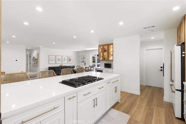 2343 E Athens Ave, Orange, CA 92867 - kitchen with gas cooktop, visible vents, freestanding refrigerator, light wood finished floors, and white cabinetry