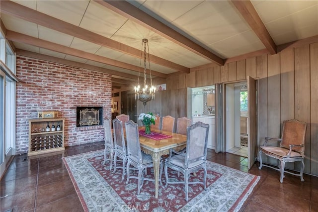 5646 E Park Circle Dr, Fresno, CA 93727 - dining space with wooden walls, a chandelier, beam ceiling, brick wall, and dark tile patterned floors