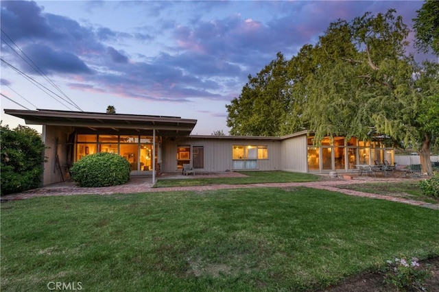 5646 E Park Circle Dr, Fresno, CA 93727 - back of house at dusk with a lawn and a patio