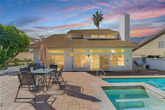 3381 Deaver Dr, Corona, CA 92882 - rear view of property with stucco siding, fence, a patio, and a fenced in pool