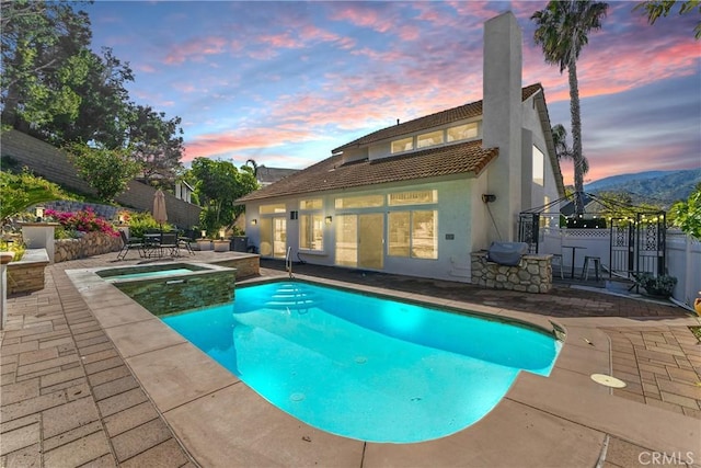 3381 Deaver Dr, Corona, CA 92882 - pool at dusk with a gazebo, a patio area, a pool with connected hot tub, and fence