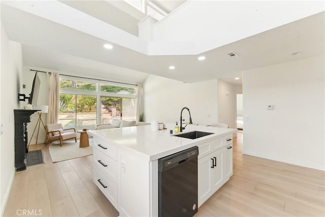 3381 Deaver Dr, Corona, CA 92882 - kitchen featuring white cabinets, a kitchen island with sink, a sink, light wood-type flooring, and black dishwasher