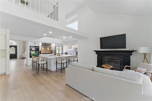 3381 Deaver Dr, Corona, CA 92882 - living area with recessed lighting, a high ceiling, light wood-style floors, and a premium fireplace