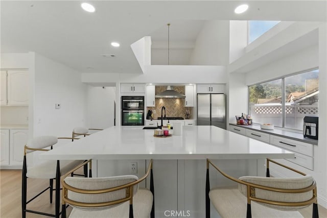 3381 Deaver Dr, Corona, CA 92882 - kitchen with white cabinets, decorative backsplash, a breakfast bar, and stainless steel fridge