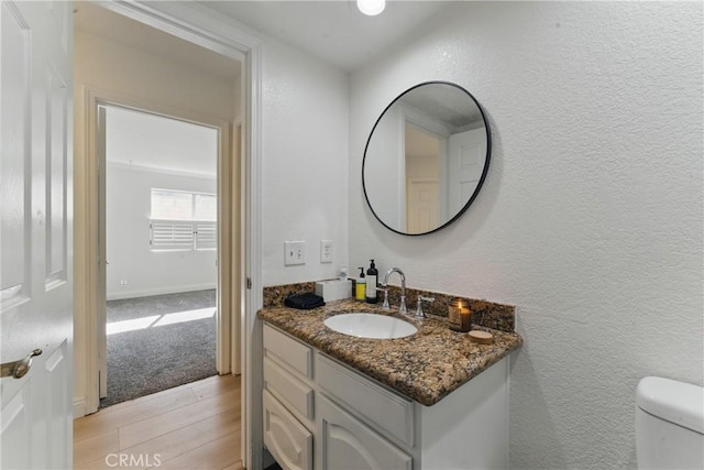3381 Deaver Dr, Corona, CA 92882 - half bath with a textured wall, wood finished floors, vanity, and toilet