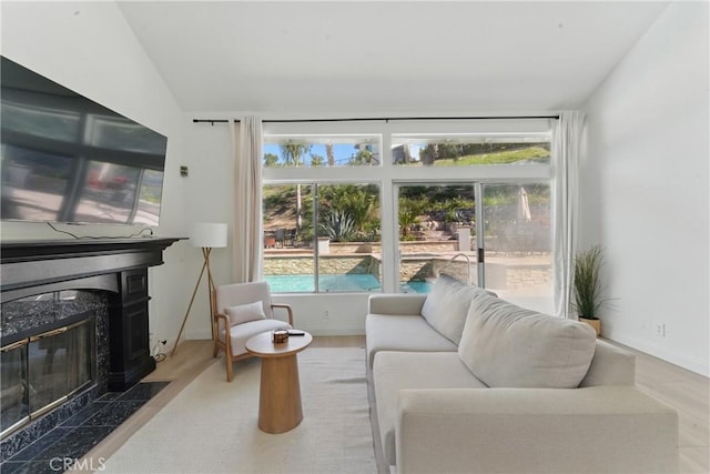 3381 Deaver Dr, Corona, CA 92882 - living room featuring wood finished floors, a fireplace, baseboards, and a wealth of natural light