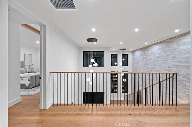 hallway featuring baseboards, wood finished floors, visible vents, and recessed lighting