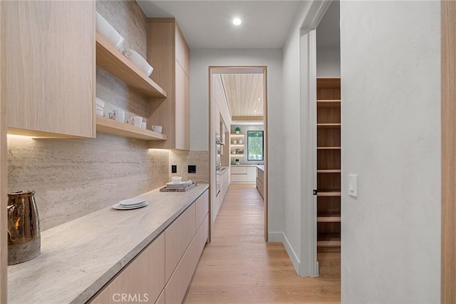 hallway featuring light wood-style flooring and recessed lighting
