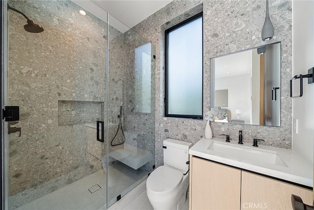 full bathroom featuring toilet, tile walls, vanity, and a stall shower