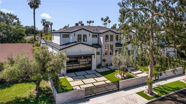 view of front of house featuring a gate, a fenced front yard, a front lawn, stucco siding, and an attached garage
