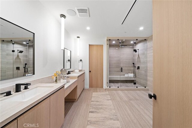 full bath with visible vents, recessed lighting, wood finished floors, a shower stall, and vanity