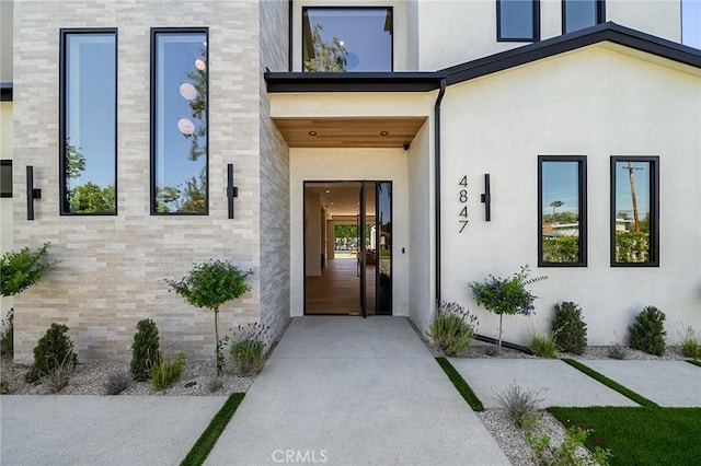 view of exterior entry featuring stucco siding