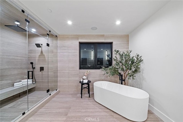 bathroom featuring recessed lighting, a freestanding bath, and a stall shower