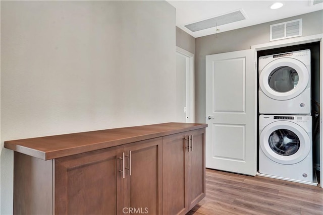 23206 W Remington Way, West Hills, CA 91307 - laundry area with attic access, light wood finished floors, visible vents, stacked washer and clothes dryer, and laundry area