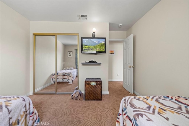 carpeted bedroom with baseboards, a closet, and visible vents