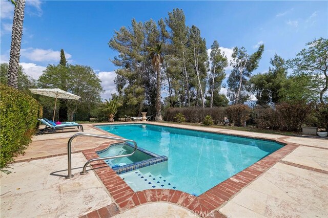 view of swimming pool with a patio area and a pool with connected hot tub