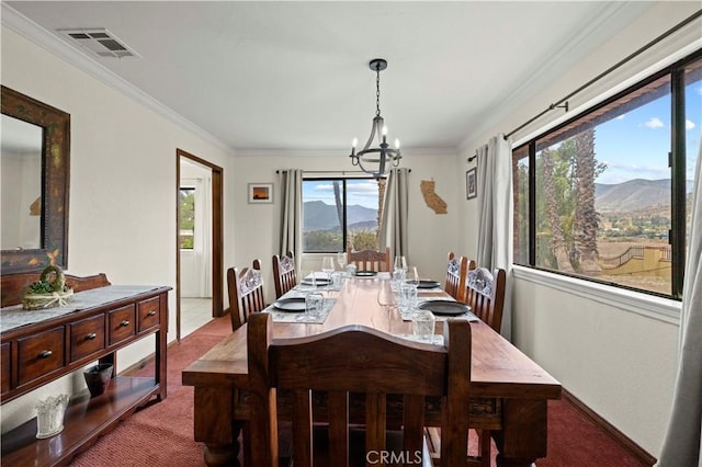 dining area featuring an inviting chandelier, carpet flooring, a mountain view, and visible vents