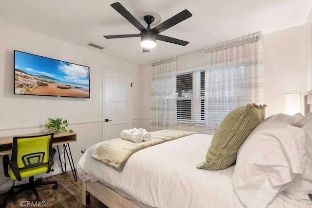 bedroom with a ceiling fan, visible vents, and wood finished floors