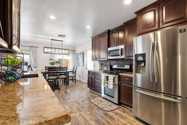 kitchen featuring visible vents, wood finished floors, dark brown cabinets, stainless steel appliances, and recessed lighting