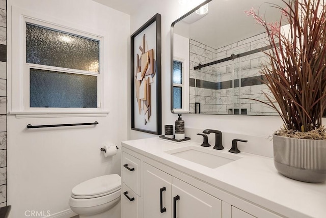 bathroom featuring vanity, toilet, and a shower stall