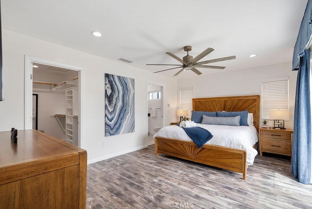 bedroom with visible vents, wood finished floors, baseboards, recessed lighting, and a spacious closet