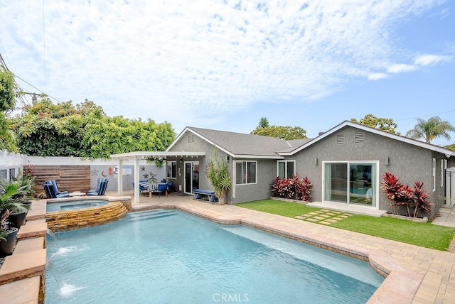 rear view of house featuring a fenced in pool, an in ground hot tub, and stucco siding
