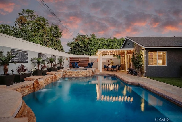 pool at dusk featuring a pergola, a fenced in pool, a fenced backyard, an in ground hot tub, and a patio area