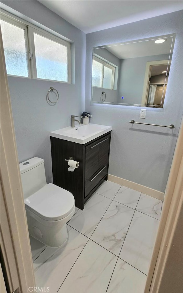 2108 Raleigh Ave, Costa Mesa, CA 92627 - bathroom with marble look tiles, vanity, and toilet