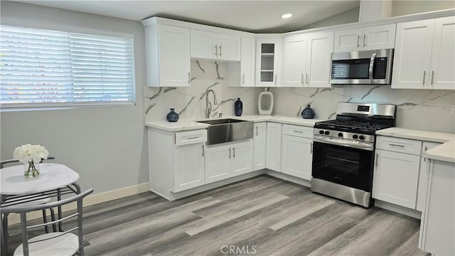 2108 Raleigh Ave, Costa Mesa, CA 92627 - kitchen with stainless steel appliances, a sink, light countertops, white cabinets, and recessed lighting