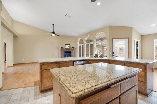 19501 Kinai Rd, Apple Valley, CA 92307 - kitchen with open floor plan, ceiling fan, a fireplace, visible vents, and a kitchen island