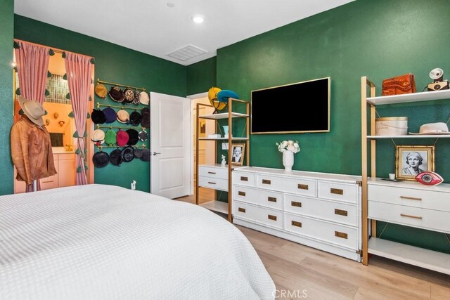 bedroom featuring wood finished floors and visible vents