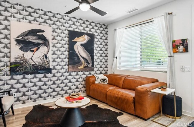 living area with ceiling fan, baseboards, wood finished floors, and visible vents