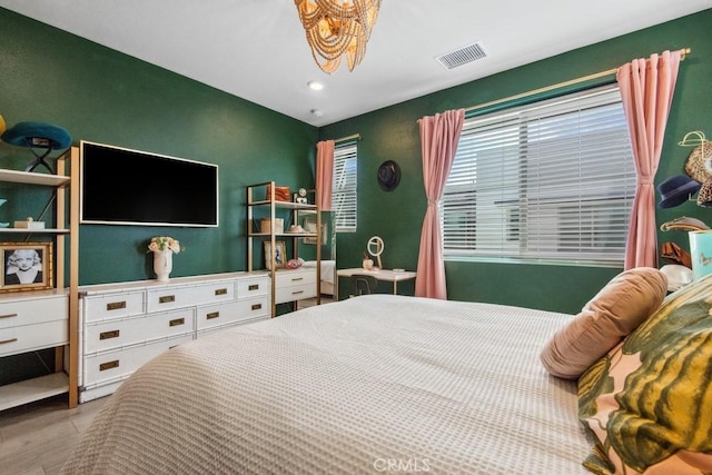 bedroom with recessed lighting, wood finished floors, visible vents, and an inviting chandelier