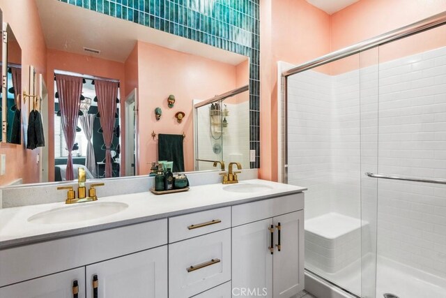 ensuite bathroom featuring a shower stall, a sink, visible vents, and ensuite bathroom