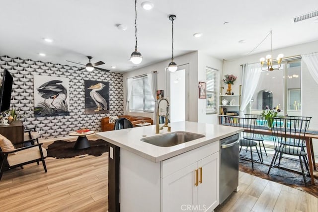 kitchen featuring light wood-style flooring, a sink, visible vents, ceiling fan with notable chandelier, and dishwasher