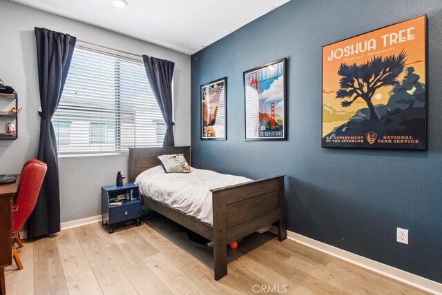 bedroom featuring baseboards, wood finished floors, and recessed lighting