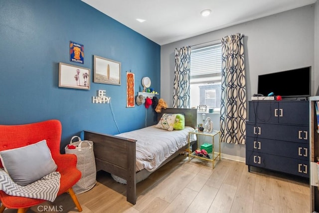 bedroom with baseboards, wood finished floors, and recessed lighting