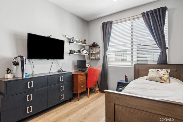 bedroom featuring multiple windows and light wood-type flooring